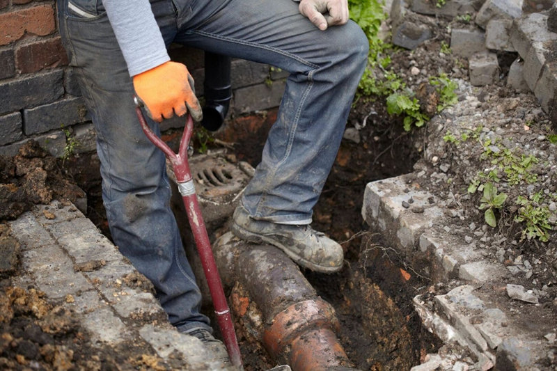 worker repairing septic line