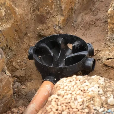 A pipe that is in the ground with rocks.